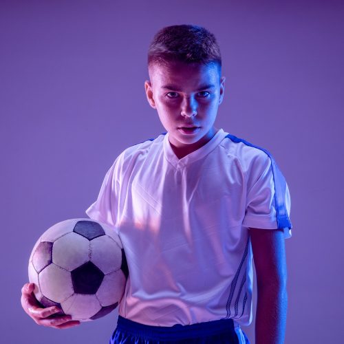 young-boy-as-a-soccer-or-football-player-on-dark-wall (1)
